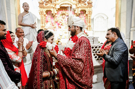 A candid frame celebrating the exchange of wedding garlands.