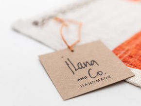 Close-up of a handmade product label reading Ilana and Co attached to fabric photographed by Alex Vainstein in Boston