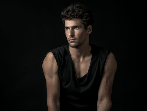 Dramatic studio portrait of a man in Boston with dark background and moody lighting