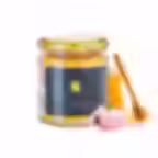 Cherry blossom honey jar by Caravella Fine Food with honey dipper on white background