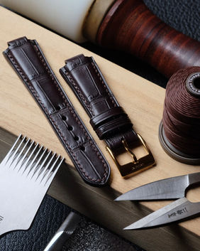 Bracelet de montre (bombé 6 à 3 mm d’épaisseur) entièrement fait main et cousu main en cuir de crocodile coffee, doublure veau Zermatt, fil de lin coffee (couture S), peinture des bords vert dark brown et boucle dorée.