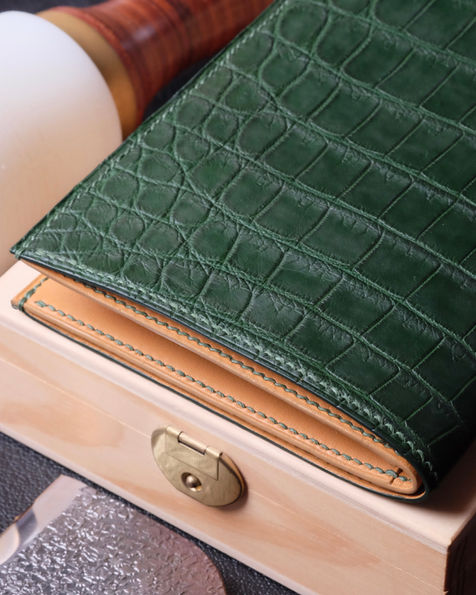 Long wallet no. 60 in green crocodile leather, interior in smooth Baranil gold calfskin, dark green linen thread and dark green edge painting.
