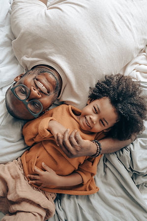 candid-black-man-and-kid-on-bed-4546024.