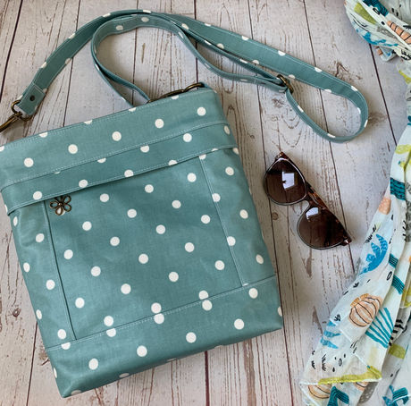 Handmade, bespoke Oilcloth Crossbody Bag in a teal and white polka dot oilcloth fabric.