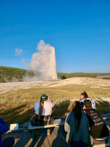Guests take in the power of geyser eruption (from a safe distance!) in Yellowstone National Park