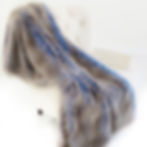 Sheared Faux Chinchilla Luxury Throw draped on white chair, soft blue accents, cozy home decor.