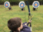 Young boy shooting at archery targets using a bow and arrow
