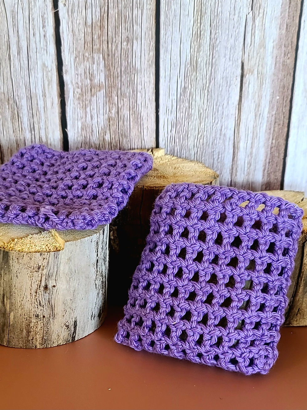 Thumbnail: Two purple crocheted soap sacks on wood