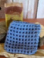 Blue crocheted soap sack next to bar of soap