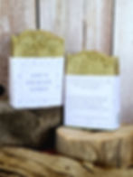 2 bars of soap sitting on pieces of wood in front of a wood background.