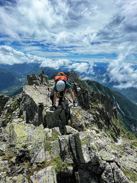 hiker climbing over knife ridge