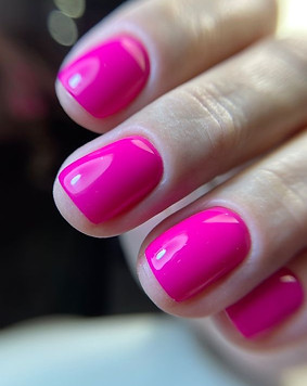 Close-up of vibrant hot pink gel manicure on natural nails – summer nail design in Milos