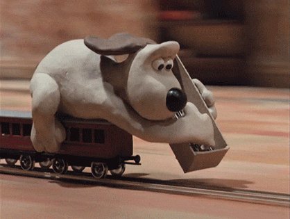 Claymation of dog setting a train track