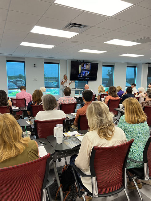 Stacy Durbin, President of Semonin REALTORS®, leading a weekly business meeting as agents gather in a training room to stay informed on industry updates and market changes.