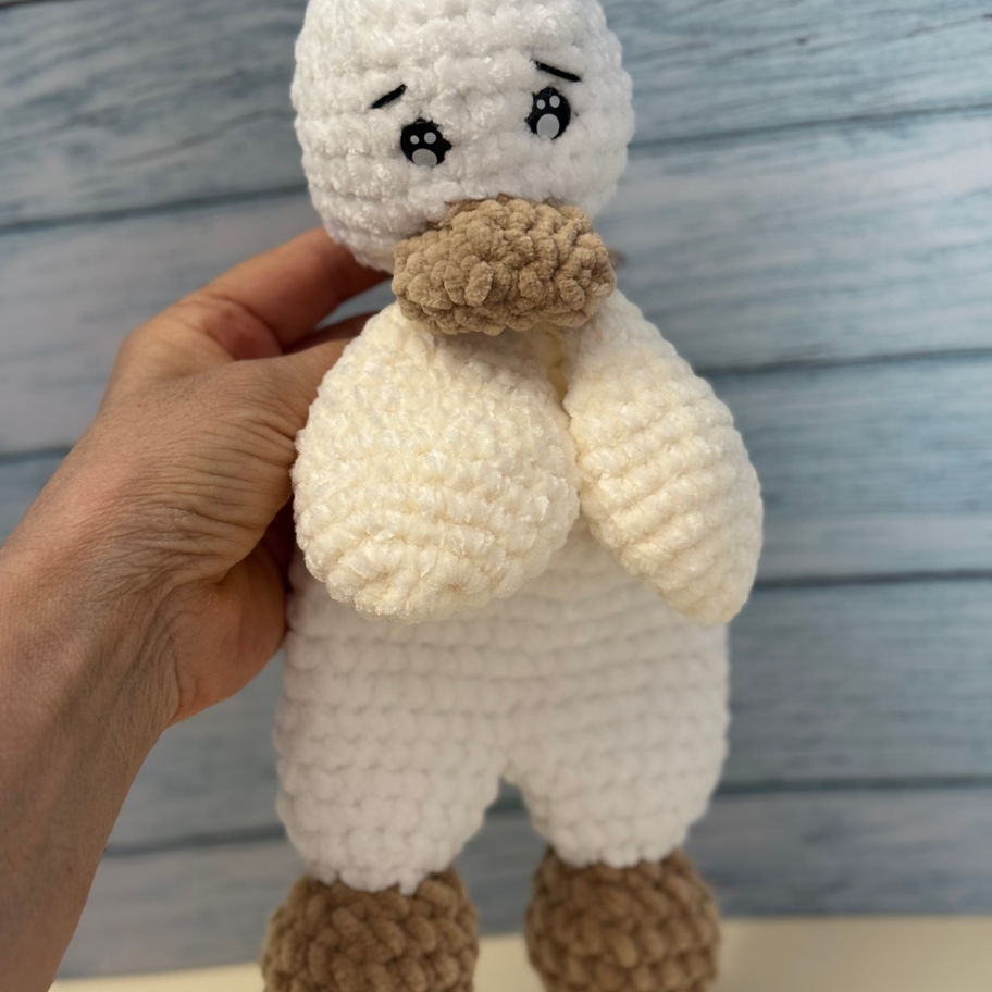 Papero amigurumi in ciniglia tenuto tra le mani, vista completa.