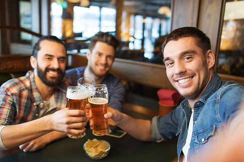 people, leisure, friendship, technology and bachelor party concept - happy male friends ta