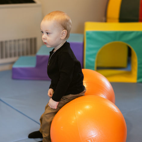 Pediatric therapist supporting a baby learning to stand and take first steps during a therapy session in Mechanicsburg, PA