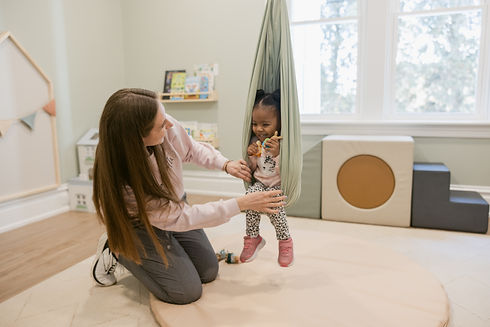 A pediatric occupational therapist works with a toddler on a sensory swing during a sensory integration therapy session at Clear Path Pediatric Therapy in Mechanicsburg, Pennsylvania.