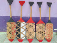 Pagaies de canoë ornées d'inscriptions indigènes traditionnelles de la réserve du Xingu, témoignage du patrimoine artistique de la communauté locale.