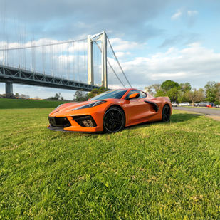 Amplify Orange C8 Corvette Stingray, a bold and dynamic sports car featuring a mid-engine design, sharp lines, and eye-popping color. The vibrant orange exterior and aggressive stance highlight its racing pedigree. Rent this powerful machine from 369 Exotics Rentals for an unforgettable blend of speed and style.