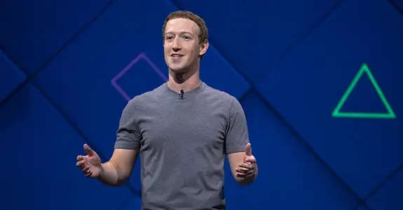 mark zuckerberg de camisa cinza e braços entreabertos