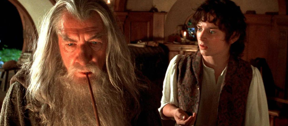 Imagem mostra Gandalf ostentando seu cachimbo com Frodo com a mão parcialmente levantada