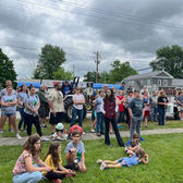 Large crowd of people gathered on a lawn, cloudy sky overhead in Chatham TWP.