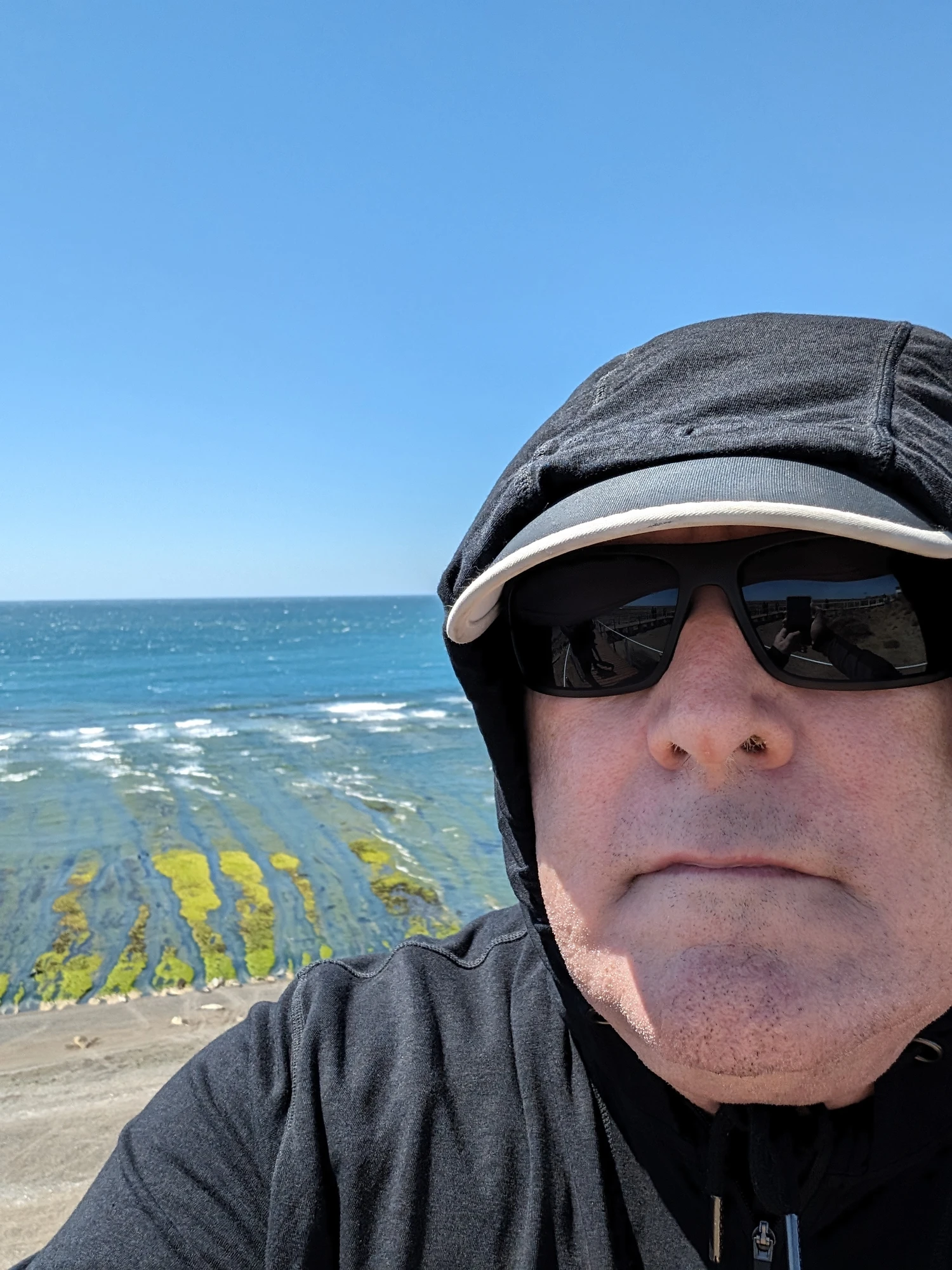 Man in sunglasses and hoodie near the coast in Uruguay