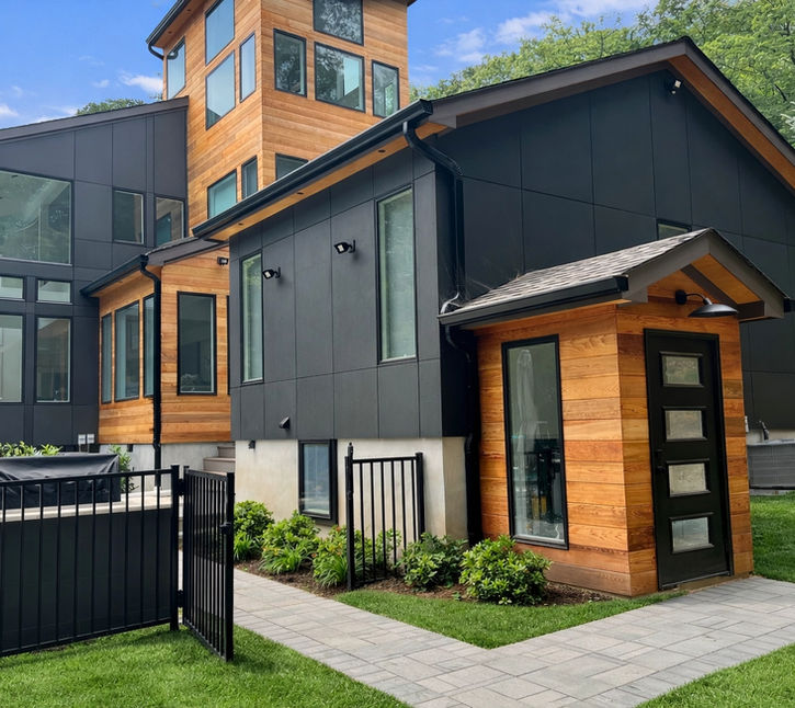 Modern luxury home renovation by Peluso Construction featuring black exterior cladding, natural wood siding, contemporary architecture, and expansive custom windows in Rockland County NY.