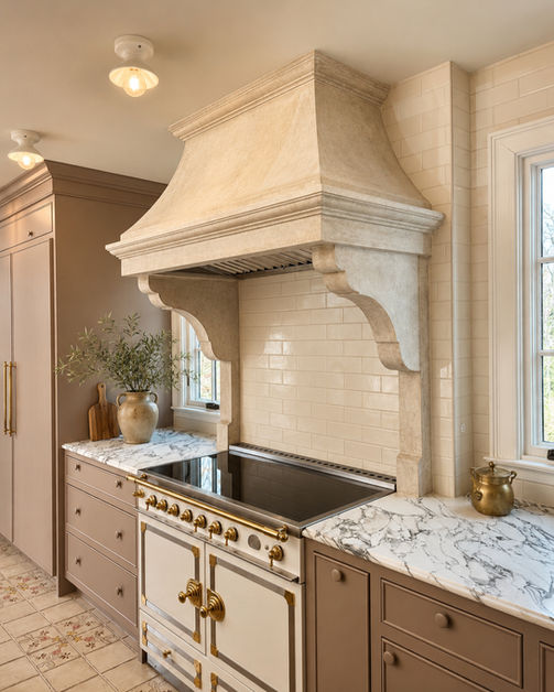 Luxury custom kitchen renovation by Peluso Construction featuring a handcrafted stone range hood, marble countertops, custom cabinetry, premium range, and elegant high-end finishes in Bergen County NJ.