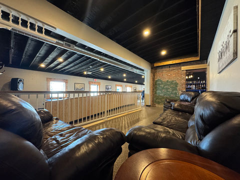 Comfortable lounge with leather seating overlooking dining area