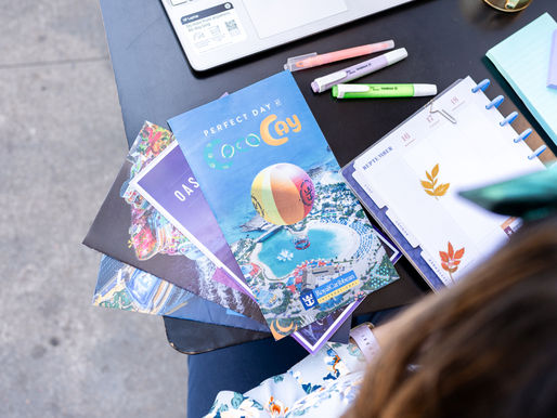 Planning the perfect getaway with a collection of vibrant brochures and a neatly organized planner, setting the stage for an exciting cruise adventure.