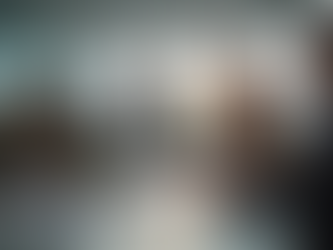 Business meeting with five people in a bright office, engaged in discussion. A man presents while others listen. Sunlight through windows.