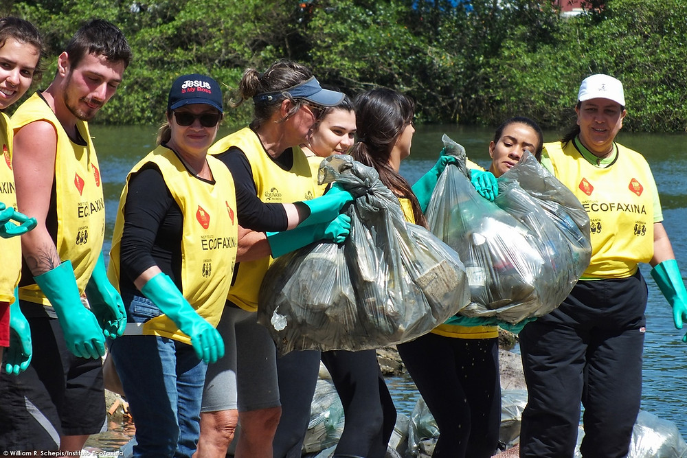 Voluntários retiram sacos de lixo cheios de plástico e isopor coletados no rio São Jorge, em Santos.