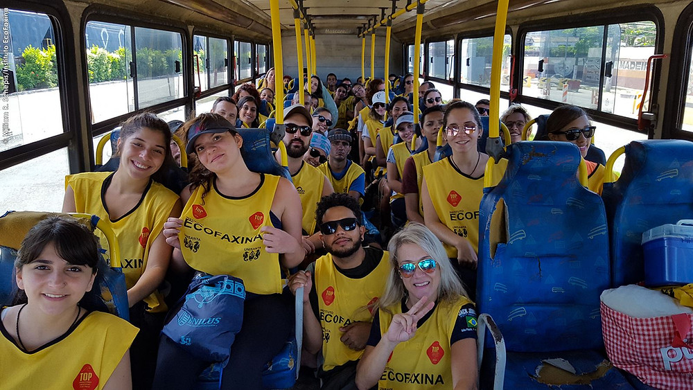 Voluntários posam para foto no ônibus a caminho do manguezal.