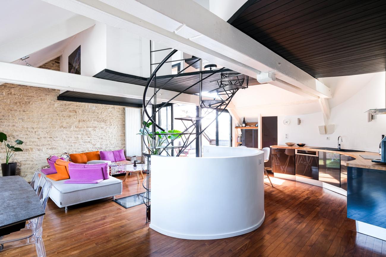 Séjour du triplex avec escalier en colimaçon et poutres