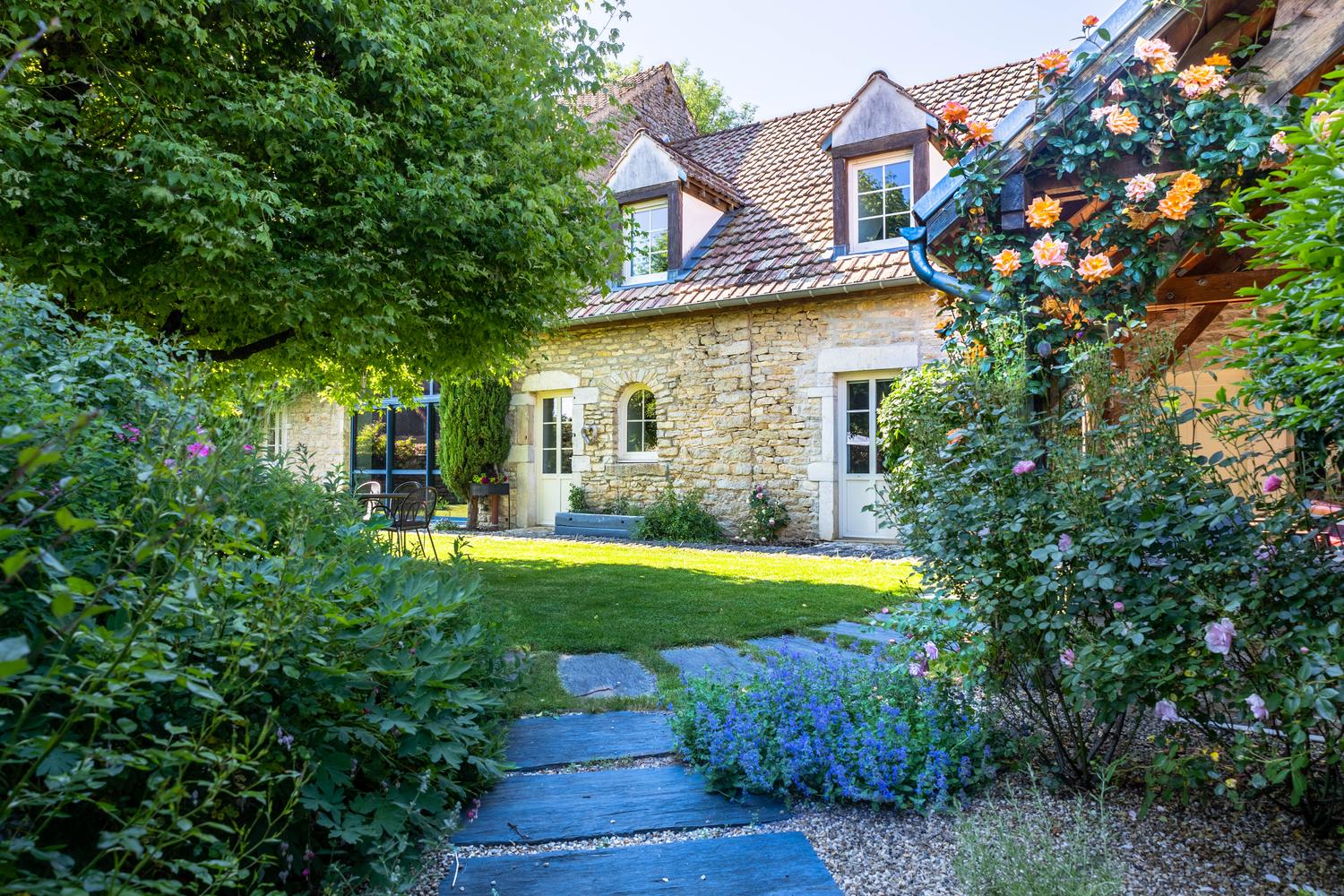 Jardin arboré et façade fleurie