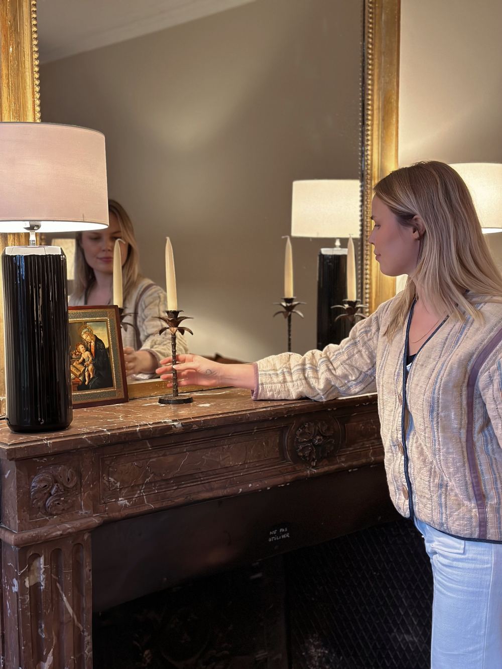 Virginie ajuste la décoration d'une cheminée en marbre