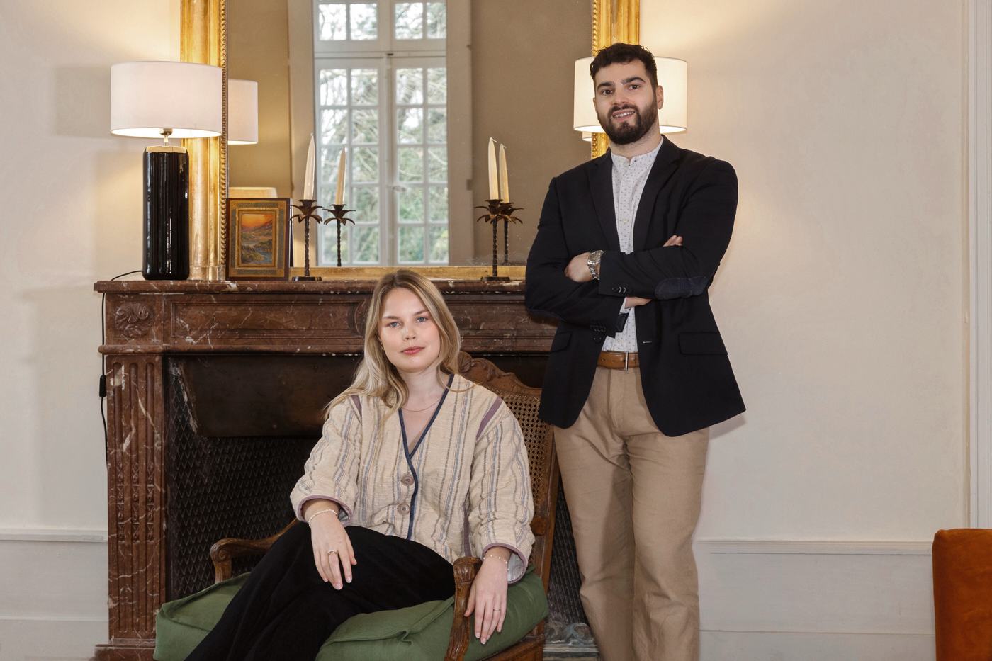 Rolf et Virginie, fondateurs des Suites Indivio, devant une cheminée