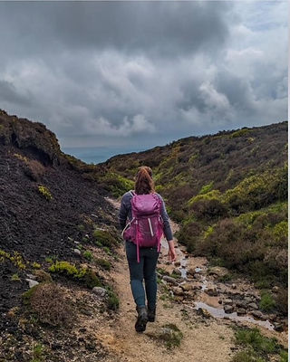A woman walking between peat hags on Kinder Scout