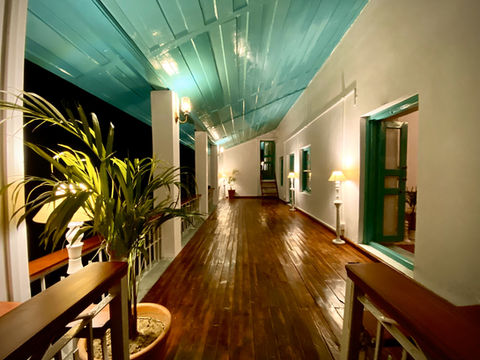 Warmly lit corridor with wooden floor at Moonshine Villa in Bir Billing