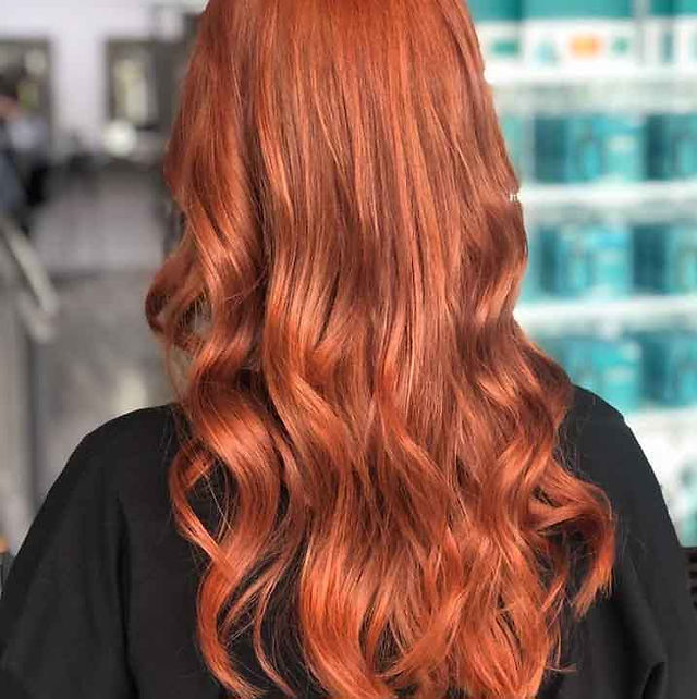Client is facing back showing her new hair colour, which is a global overall hair colour in orange copper tones