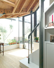 internal photo showing staircase, with exposed structural steel column next to the glazed wall.