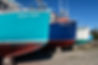 Colourful boat hulls lined up in a boatyard