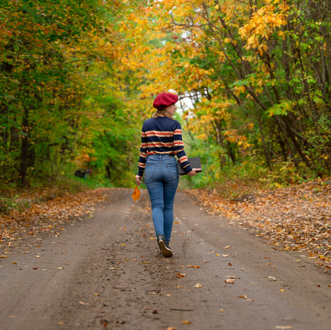 vibrant lifestyle photo of stylish girl walking on autumn trail