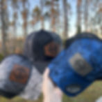 Custom laser engraved gifts including three camo trucker hats.