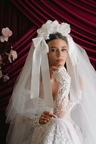 Bride wearing a white veil and floral headpiece with soft luxury bridal makeup