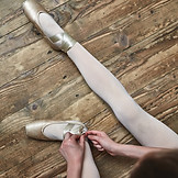 Girl Lacing Up Her Ballet Shoes
