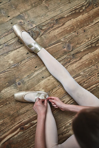Girl Lacing Up Her Ballet Shoes