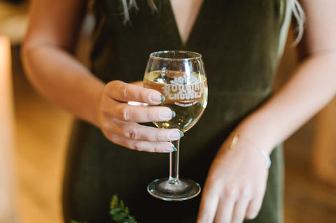 Woman holding a glass of Booking House wine